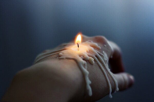 Burning molten candle on hand