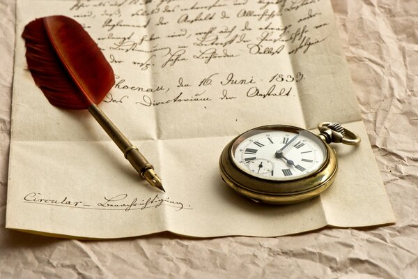 Papel con texto escrito en el que se encuentra un reloj y una pluma estilográfica con una pluma roja