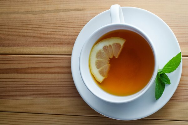 Té de limón y menta en una taza de color blanco