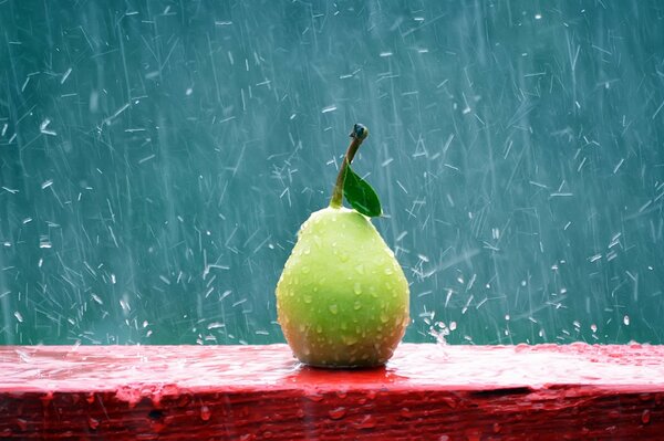 A pear on a red bench in the rain