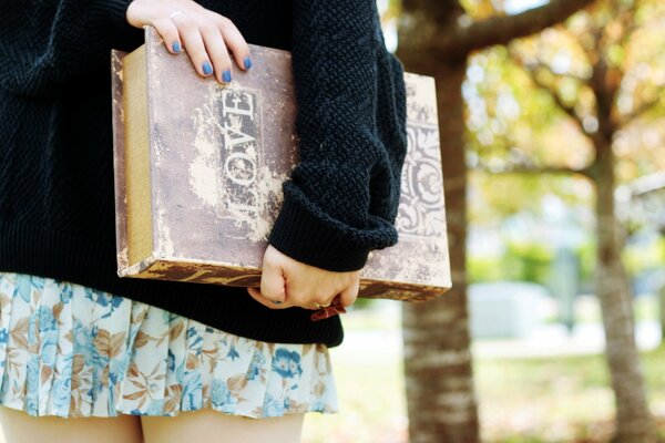 Chica con libro de amor con manicura azul