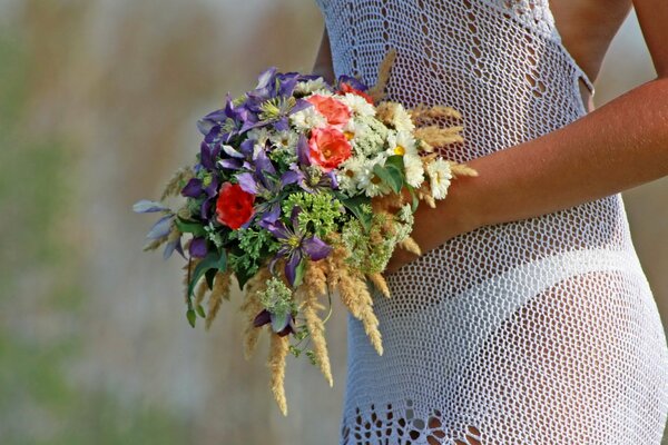 A girl in a white dress with a bouquet of flowers