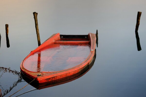 Barco rojo atado en el lago