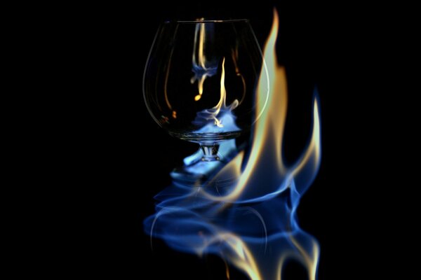 Verre de cristal embrassé par une flamme bleue