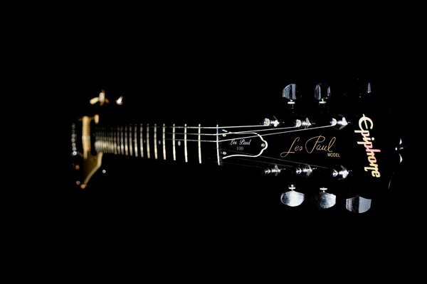 Guitar strings and neck on a black background