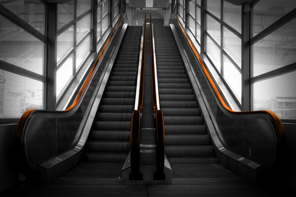 Escalator with handrails in a glazed room