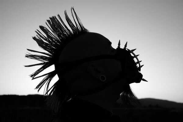 Silhouette eines Punk in einem stacheligen Maulkorb