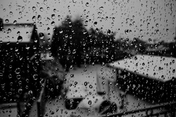 Title winter buildings and roofs behind glass with drops