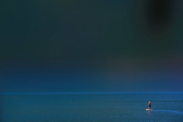 Un hombre en una tabla en el mar solo