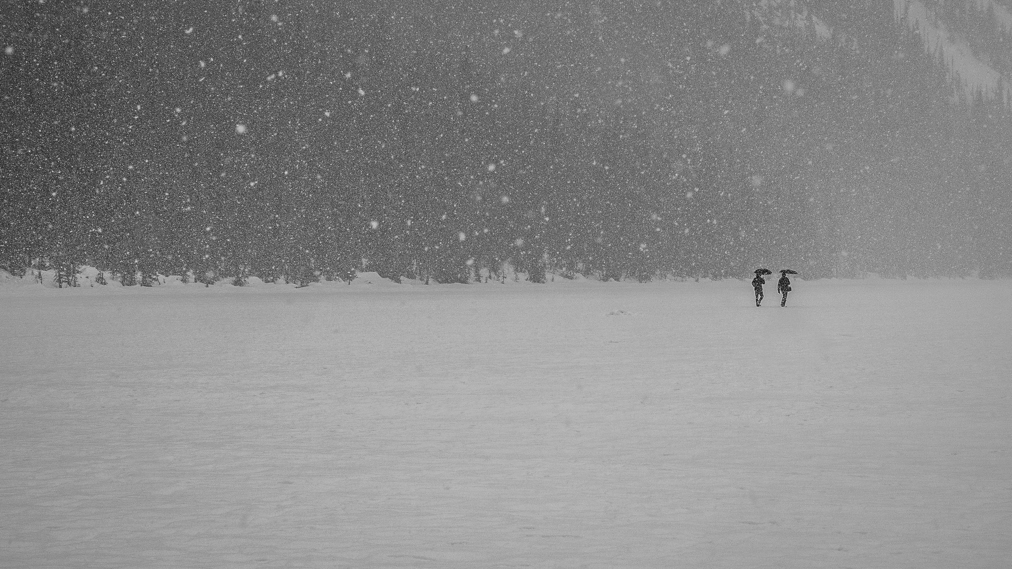 gens marche lac congelé hiver neige parapluie montagnes