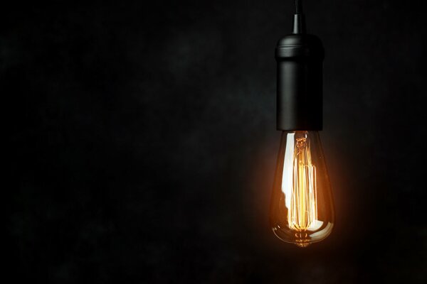 Electric light bulb as a symbol of light in the dark