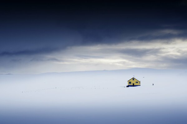 Casa solitaria en un campo cubierto de nieve