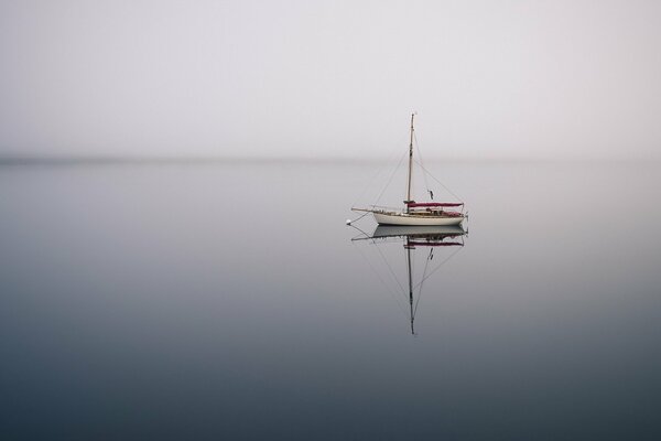 In a beautiful sea, a boat floating in the fog