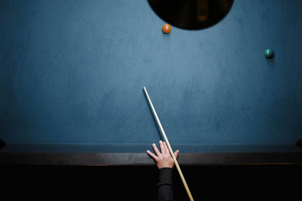 A hand with a cue on a billiard tablemignon