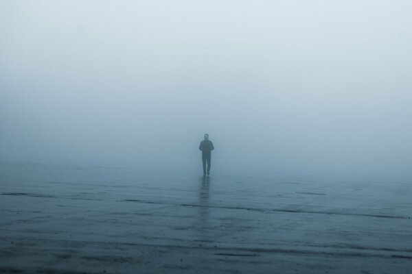 Uomo solitario nella nebbia durante la pioggia