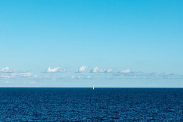 Voile blanche solitaire dans le brouillard bleu de la mer