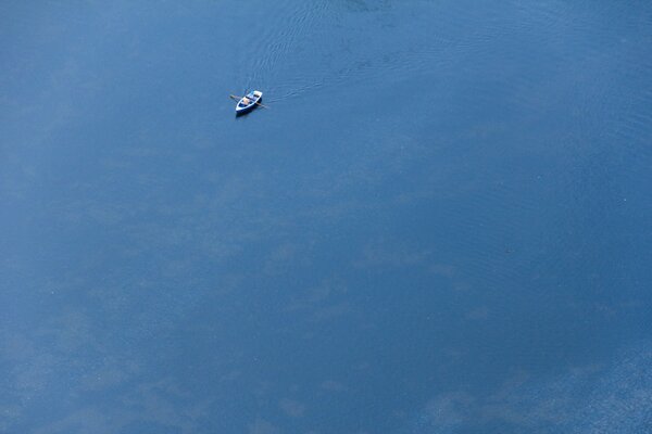 Enorme mare blu con barca solitaria