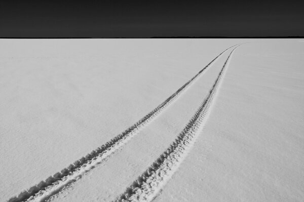 Tire tracks from a snowmobile on a snowy terrain