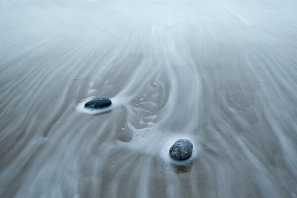 Rocks lying on the sand during the surf