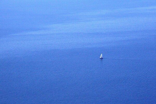 Un solitario velero en el mar azul