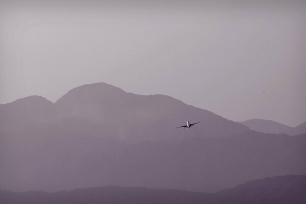 A plane flying against the background of mountains