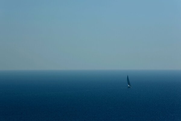 Yacht with a sail in the blue sea