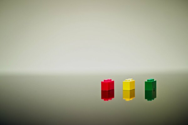 Three lego bricks in red, yellow and green