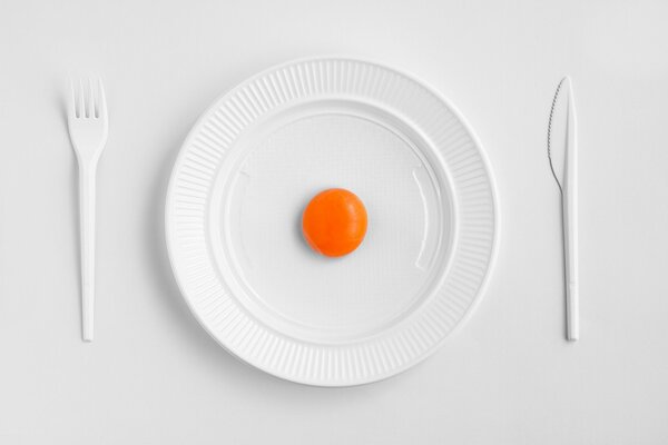 Yolk on a white plate with a fork and spoon