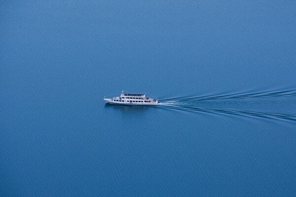 Foto de barco minimalista con un tren de ondas simétricas