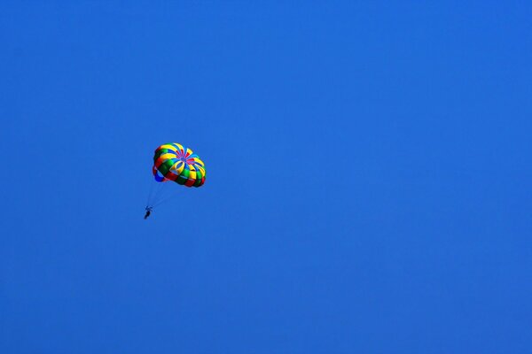 Im blauen Himmel ist ein sportlicher Fallschirmspringer