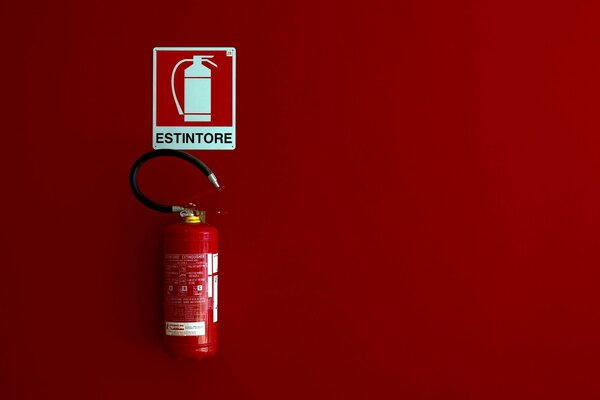 Fire extinguisher and fire extinguisher sign on a red background in minimalism