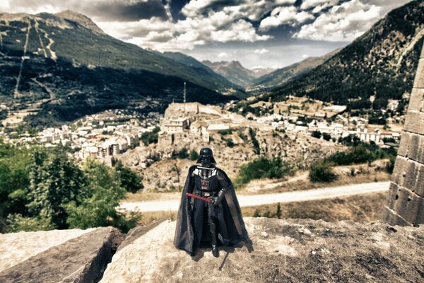 Darth Vader with a sword on the background of the old town and the mountain range