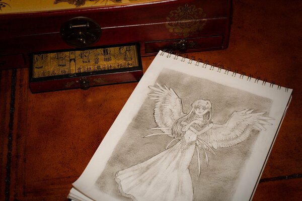 A notebook with the image of an angel and a box