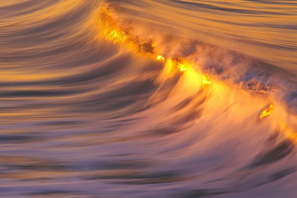 Reflection of the sunset on the crest of the sea wave