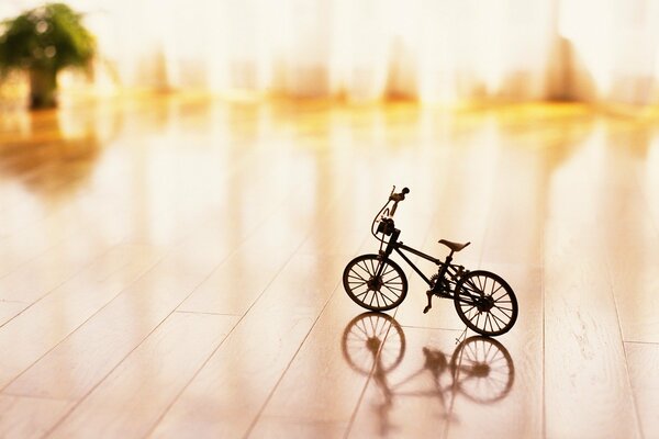 A toy bicycle on the background of a window illuminated by sunlight