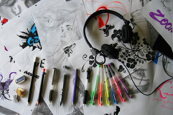 Artist s sketches, pens and headphones are in the drawings