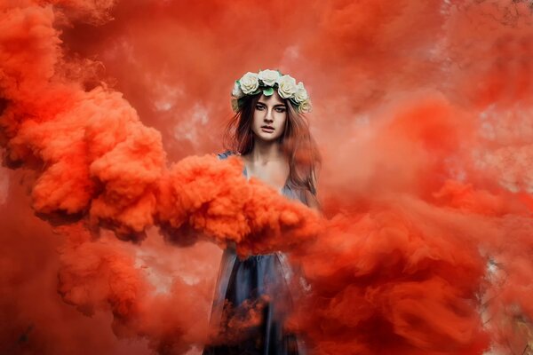 Ragazza con corona sulla testa in fumo rosso