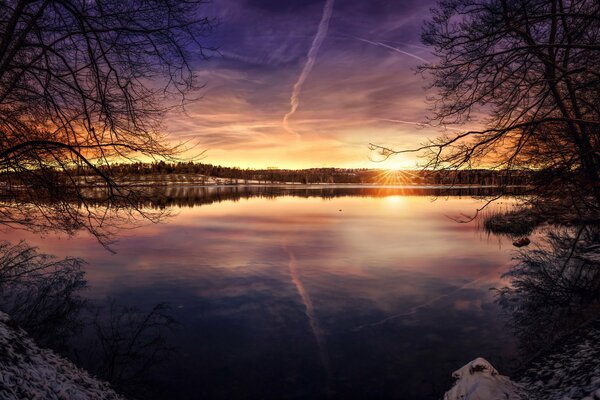 Lake on the background of the setting sun at the end of the day