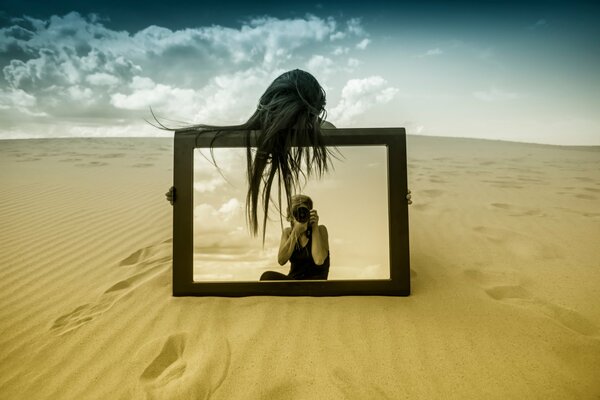 La jeune fille avec un miroir dans le désert de prendre des photos de