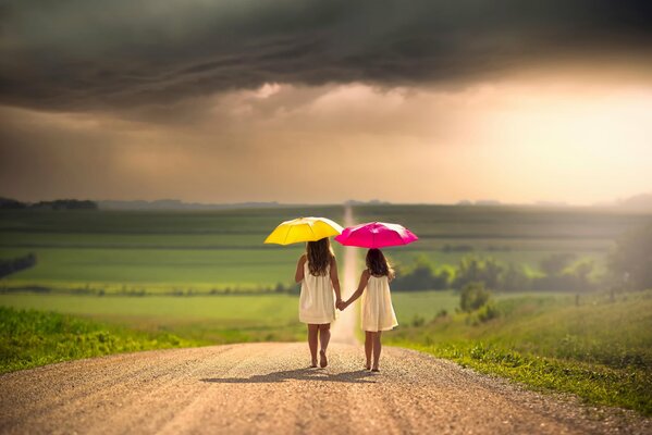 Due ragazze con ombrelli sulla strada