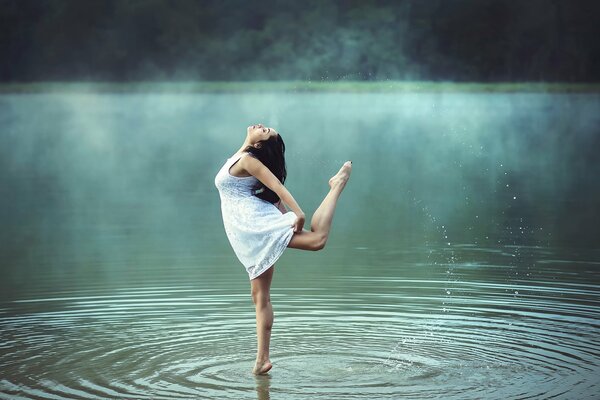 Mädchen tanzen im Wasser unter dem Nebel