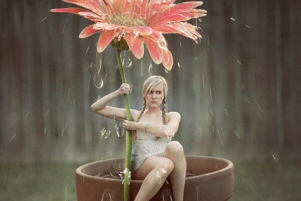 Girl with a flower in the rain