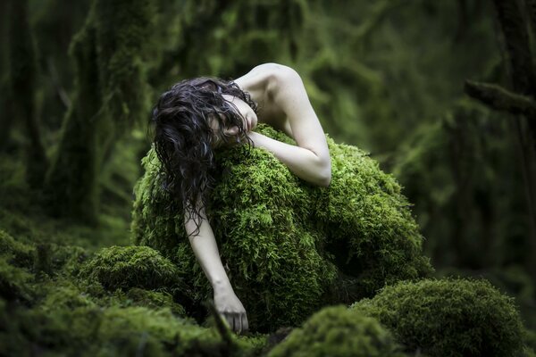 Pálida chica en el bosque en el musgo