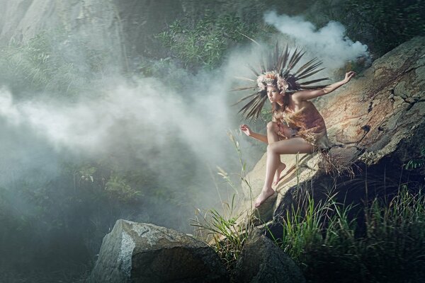 Indian woman in the fog sitting on the rocks