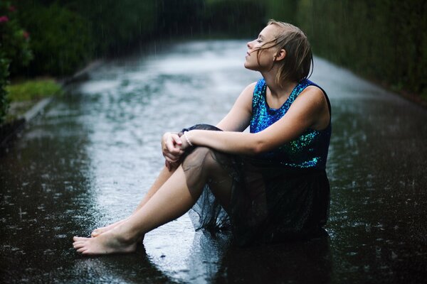 Mädchen im blauen Kleid im Regen