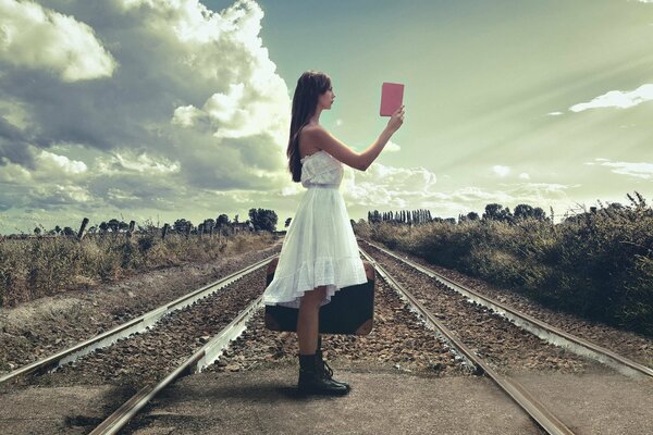 Chica en el ferrocarril con un libro en la mano