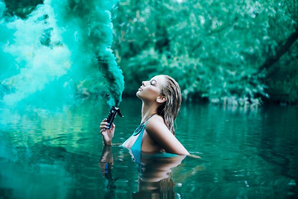 The girl in the lake blows green smoke