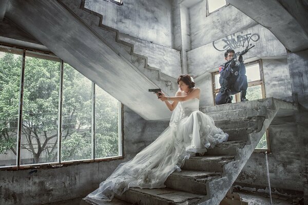 Chica en vestido de novia con armas en la mano