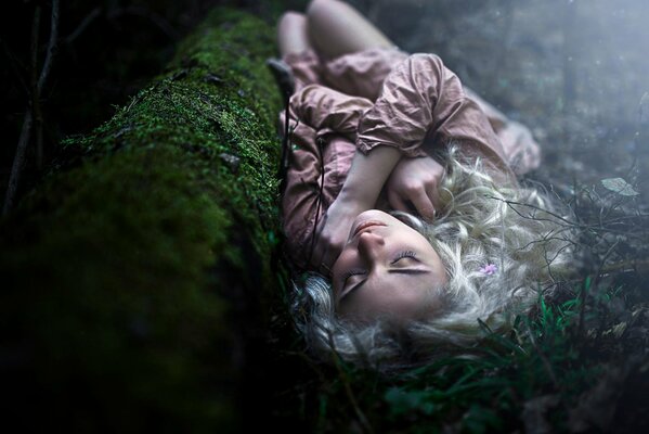 Rubia chica durmiendo en el bosque