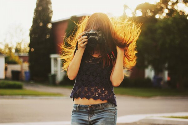 La jeune fille à la jupe en denim soulage sur l appareil photo